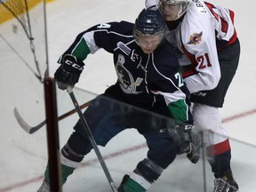 Plymouth Whalers Mathieu Henderson (L) gets checked by Windsor Spitfire Logan Brown during their game Thursday, Sept. 4, 2014, at the WFCU Centre in Windsor, ON. (DAN JANISSE/The Windsor Star)