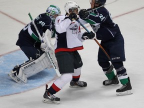 Windsor Spitfire Cristiano DiGiacinto (C) gets roughed up by Plymouth Whalers Mathieu Henderson in front of goalie Alex Nedeljkovic during their game Thursday, Sept. 4, 2014, at the WFCU Centre in Windsor, ON. (DAN JANISSE/The Windsor Star)