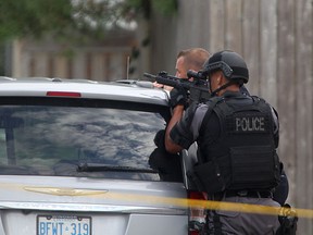 Heavily armed Windsor police officers work at the scene of a standoff at the intersection of Gladstone Ave. and Tecumseh Rd. East, Tuesday, Sept. 9, 2014.  (DAX MELMER/The Windsor Star)