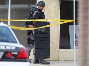 Heavily armed Windsor police officers work at the scene of a standoff at the intersection of Gladstone Ave. and Tecumseh Rd. East, Tuesday, Sept. 9, 2014.  (DAX MELMER/The Windsor Star)