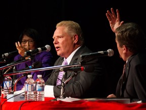 Doug Ford, centre, is pushed to answer a question as whether he will march in annual Pride parade by fellow candidates John Tory, right, and Olivia Chow as he takes part in a Toronto Mayoral Debate in Toronto on Tuesday, September 23, 2014. THE CANADIAN PRESS/Chris Young