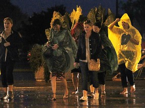 A group leaves the Shores of Erie International Wine Festival on Friday, Sept. 5, 2014, during a heavy downpour that shut down the event for the night. (DAN JANISSE/The Windsor Star)