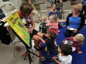 Preschoolers gather around Rose Caille, left, host of Morning Storytime at the Riverside branch of the Windsor Public Library recently. Children ages one to four are invited to build language skills through song, reading and activities. (NICK BRANCACCIO / The Windsor Star)