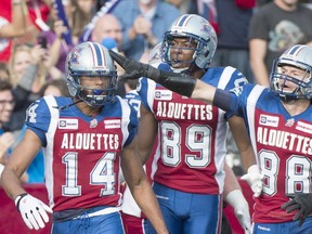 Montreal Alouettes' Brandon London (14) celebrates with teammates Duron Carter (89) and Dave Stala after scoring a touchdown against the Saskatchewan Roughriders during second half CFL football action in Montreal, Monday, October 13, 2014. THE CANADIAN PRESS/Graham Hughes