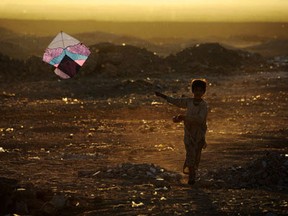 In this photograph taken on October 20,2014, an Afghan child plays with a kite on the outskirts of Herat. Afghanistan's economy has improved significantly since the fall of the Taliban regime in 2001 largely because of the infusion of international assistance. Despite significant improvement in the last decade the country is still extremely poor and remains highly dependent on foreign aid.