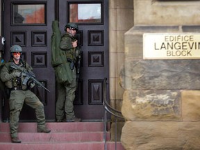 RCMP tactical officers attempt to enter the Langevin Block as police respond to an apparent terrorist attack in Ottawa. Photo taken Oct. 22, 2014. (Wayne Cuddington/Ottawa Citizen)