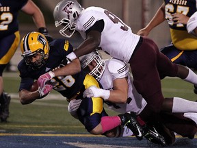 Windsor's Tarrence Crawford, left, is tackled by Ottawa's Nick Lecour, bottom, and Rashid Timbilla at Alumni Field. (TYLER BROWNBRIDGE/The Windsor Star)