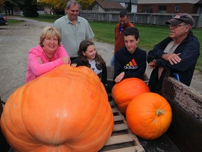 In this file photo, Rachelle and Roch Ethier, left, and family members prepare giant pumpkins for a memorial event for their son, Daniel, who died of cancer in June 2013. Daniel's cousins Slyvie and Nolan Lachance, Uncle Roger Lachance and grandfather Clement Lachance, right, admire their efforts as they prepare for the big day.  (NICK BRANCACCIO/The Windsor Star)