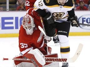 Boston's Simon Gagne, right, is checked in front of Detroit goalie Jimmy Howard Wednesday in Detroit. (AP Photo/Paul Sancya)