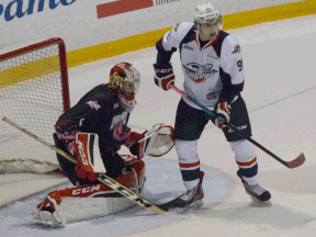 Spitfires forward Cristiano DiGiacinto, right, sets a screen in front of Owen Sound goalie Jack Flinn during the Attack's 5-4 overtime win Sunday. (Owen Sound Sun Times)