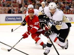 Penguins centre Sidney Crosby, right, is checked by Detroit's Kyle Quincey at Joe Louis Arena. (AP Photo/Paul Sancya)