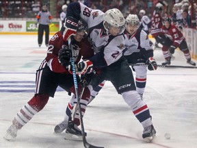 Windsor's Slater Doggett, right, battles for the puck with Guelph's Jesse Hilton at the WFCU Centre. (DAX MELMER/The Windsor Star)