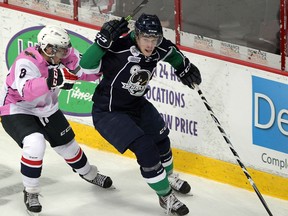 Windsor's Trevor Murphy, left, checks Plymouth's Connor Chathams in OHL action at the WFCU Centre Thursday. (NICK BRANCACCIO/The Windsor Star)