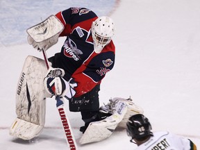 Spits goalie Alex Fontinos, left, clears the puck in front of London's Matt Rupert at the WFCU Centre. (TYLER BROWNBRIDGE/The Windsor Star)