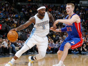 Denver's Ty Lawson, left, is guarded by Detroit's Kyle Singler in the third quarter of the Nuggets' 89-79 victory Wednesday. (AP Photo/David Zalubowski)