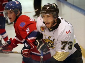 LaSalle's Graham Pickard, right, is checked by Nick Whitworth of Strathroy Wednesday at the Vollmer Centre. (NICK BRANCACCIO/The Windsor Star)