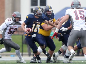 Windsor quarterback Austin Kennedy, centre, scrambles out of the pocket against the Guelph Gryphons at Alumni Field. (DAX MELMER/The Windsor Star)