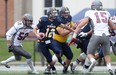 Windsor quarterback Austin Kennedy, centre, scrambles out of the pocket against the Guelph Gryphons at Alumni Field. (DAX MELMER/The Windsor Star)