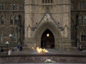 A bouquet of flowers sits in front of the eternal flame in front of Canada's House of parliament in Ottawa Thursday evening October 23, 2014, , one day after multiple shootings in the capital city and Parliament buildings left a soldier dead and others wounded. Peter McCabe/AFP/Getty Images