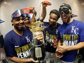 The Kansas City Royals players celebrate in the locker room after the Royals defeated the Baltimore Orioles 2-1 in Game 4 of the American League baseball championship series Wednesday, Oct. 15, 2014, in Kansas City, Mo. The Royals advance to the World Series. (AP Photo/Charlie Riedel)