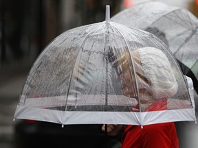 A woman walks with an umbrella along University Ave. East during a light drizzle, Friday, Oct. 31, 2014.   (DAX MELMER/The Windsor Star)