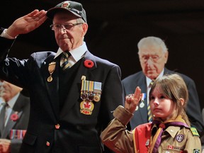 OTTAWA, ONT.: NOV 1st /2010 - from left to right are Jacques Brule (83) with Jessica Smith (9) at the Veterans Week 2010 Candlelight Tribute Ottawa--hosted by Veterans Affairs Canada and the City of Ottawa. Jean-Pierre Blackburn, Minister of Veteran Affairs and Minister of State (Agriculture), His Worship Larry OíBrien, Mayor of Ottawa and a senior representative of the Canadian Forces.  500 Veterans will take part in the procession along with Cadets, Scouts, Cubs and school children. As a gesture symbolizing the passing of the torch of remembrance, Veterans and Canadian Forces members will pass a candle to an accompanying youth who will then place the candle among others at the tribute. (File photo) (Bruno Schlumberger / Postmedia News)