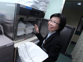 Susanna Chan, a concierge at Windsor Regional Hospital - Met Campus, prepares a warm blanket for patients admitted to emergency room, Saturday, Oct. 18, 2014.  (DAX MELMER/The Windsor Star)