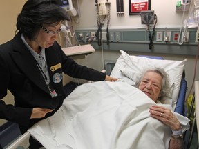 Susanna Chan, a concierge at Windsor Regional Hospital - Met Campus, prepares a warm blanket Lorraine Brisson, 91,   in the emergency room, Saturday, Oct. 18, 2014.  (DAX MELMER/The Windsor Star)