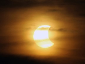 A partial eclipse is seen over Windsor on Thursday, October 23, 2014. The eclipse was visible until it dropped below the clouds in the evening sky.                (TYLER BROWNBRIDGE/The Windsor Star)