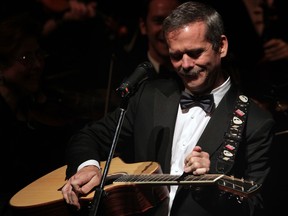 Canadian astronaut Chris Hadfield adjusts his guitar after starting off in the wrong key with Windsor Symphony Orchestra during Toldo Pops concert at Windsor's Capitol Theatre Friday October 16, 2014.  (NICK BRANCACCIO/The Windsor Star)