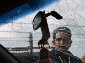 Sunil Nar looks through the cracked windshield of his van in Windsor on Monday, October 20, 2014. Nar's hood flew open while he was driving along the I75 in Detroit. Customs officers opened his hood at the border and Nar believes they failed to secure it properly.               (TYLER BROWNBRIDGE/The Windsor Star)