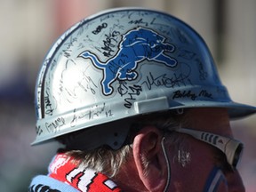 A man wears a hard hat with Detroit Lions signatures during the NFL Fan Rally in Trafalgar Square, London, Saturday, Oct. 25, 2014. The Atlanta Falcons will play the Detroit Lions in an NFL football game at London's Wembley Stadium on Sunday Oct. 26. (AP Photo/Tim Ireland)