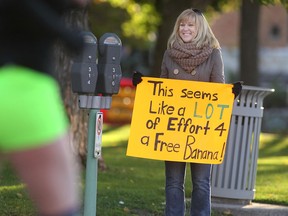 Janice Cohoe, from Windsor, encourages runners with humour during the 2014 Detroit Free Press Talmer Bank Marathon, Sunday, Oct. 19, 2014.  Cohoe ran the half marathon the last two years and is referring to the banana runners are given at the conclusion of the race.  (DAX MELMER/The Windsor Star)