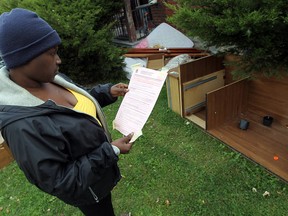 Leslie Fedee looks over a clean-up order that was posted to her door at her home in Windsor on Thursday, October 30, 2014. Fedee claims the mess has been there since she moved in and was promised by the management company that it would be cleaned up. (TYLER BROWNBRIDGE/The Windsor Star)