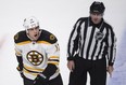 Boston Bruins' Milan Lucic reacts as he is escorted off the ice by linesman Michel Cormier after receiving a minor penalty in the final seconds of their game against the Montreal Canadiens  Thursday, October 16, 2014 in Montreal. (THE CANADIAN PRESS/Paul Chiasson)