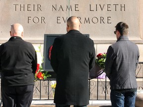 Three men pay tribute to Cpl. Nathan Cirillo at the downtown Windsor, ON. cenotaph on Thursday, Oct. 23, 2014. (DAN JANISSE/The Windsor Star)