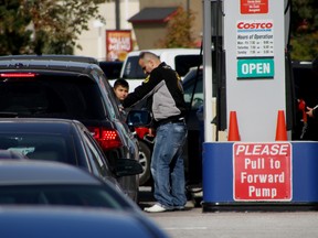 In this file photo, a motorist puts fuel in his car at a price of $1.07 a litre, Sunday, Oct. 19, 2014 at the Costco Wholesale gas station on Walker Road. Prices dipped to an average of around $1.10 a litre over the weekend at gas stations in Windsor. (RICK DAWES/The Windsor Star)