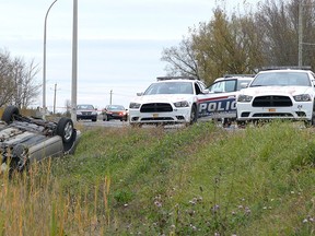 Police cruisers are parked next to an overturned car in St-Jean-sur-Richelieu, Que. on Monday Oct. 20, 2014. One of two soldiers hit by a car on Monday in Saint-Jean-sur-Richelieu, Que., died of his injuries early Tuesday, according to Quebec provincial police. THE CANADIAN PRESS/Pascal Marchand