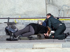Ottawa lawyer Barbara Winters gives mouth-to-mouth to fallen soldier, Cpl. Nathan Cirillo, at the War Memorial as police respond to an apparent terrorist attack in Ottawa on October 22, 2014. (Wayne Cuddington/Ottawa Citizen)