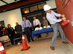 Windsor Mayor Eddie Francis swings a sledgehammer at a wall in the Art Gallery of Windsor building on Oct. 17, 2014. The first floor of the building will be renovated for an expansion of Windsor's Community Museum. (Tyler Brownbridge / The Windsor Star)