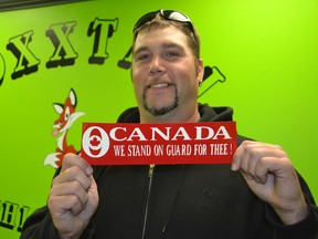 Ryan Fox, owner of Foxxtail Graphics and Signs in Kingsville, has developed a sticker that reads – Canada We Stand On Guard For Thee – that he’s selling with all proceeds going to the family of Cpl. Nathan Cirillo who was gunned down while standing guard at the National War Memorial in Ottawa. (JULIE KOTSIS/The Windsor Star)