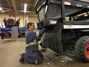 The City of Windsor Parks and Recreation Dept. is busy preparing for the winter season. Mechanic George Farrugia equips a lawn mower on Friday, Oct. 31, 2014, with a leaf mulching attachment to tackle the heavy leaf load. (DAN JANISSE/The Windsor Star)