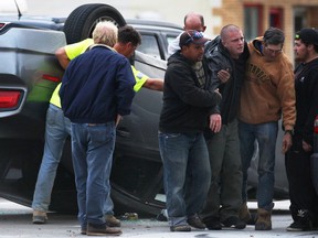 A group of Good Samaritans help a man involved in a roll over accident on Wed. Oct. 29, 2014, on Wyandotte St. E. at Edward Ave. in Windsor, ON. The accident occurred around 6 p.m. A group of men quickly smashed the side window of the car and pulled the injured man to safety. (DAN JANISSE/The Windsor Star)