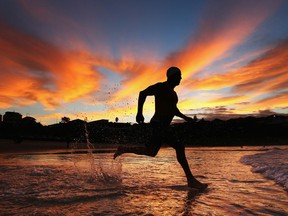 It’s easy to come up with excuses not to exercise. It’s more difficult to get back into your routine after a layoff from your workouts. A swimmer runs into the water at dawn at Bondi Beach in Sydney, Australia, in this March 2012 photo. (Ryan Pierse / Getty Images files)