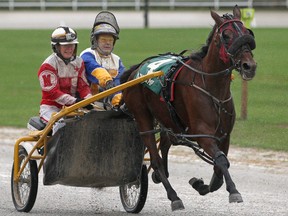 With the GoPro camera on her helmet, Windsor Star health and fitness reporter Kelly Steele, left, rides with Rob Sparling during a media harness race at Leamington Raceway on Saturday. (DAX MELMER / The Windsor Star)