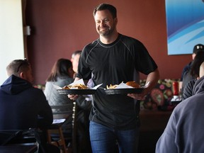Ryan Odette of Mamo Burger in Windsor serves meals during a busy lunch time recently. The popular 80-seat restaurant does not take reservations. (DAN JANISSE / The Windsor Star)