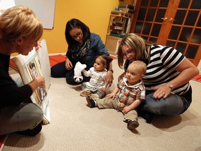 Jill St. Louis reads to Beata Spadafora and her daughter Alana, middle, and Danielle Bonnevie and her son Brock during a baby sign language class in LaSalle recently. (TYLER BROWNBRIDGE / The Windsor Star)