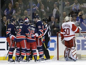 Detroit Red Wings goalie Jonas Gustavsson (50), of Sweden, watches as the New York Rangers celebrate a goal by Rick Nash during the first period of an NHL hockey game Wednesday, Nov. 5, 2014, in New York. (AP Photo/Frank Franklin II)