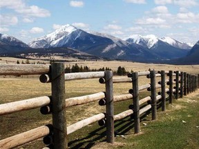 The Rocky Mountains form a backdrop for a fence line along the road in Calgary on May 22, 2009. (Gavin Young/Postmedia News)