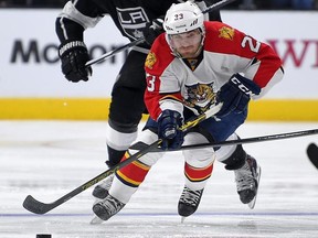 Florida Panthers Rocco Grimaldi, right, moves the puck as Los Angeles Kings left wing Dwight King gives chase during the third period of an NHL hockey game, Tuesday, Nov. 18, 2014, in Los Angeles. The Kings won 5-2. (AP Photo/Mark J. Terrill)